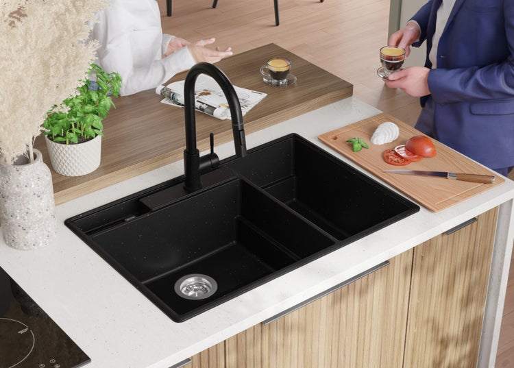 Schwarzes Küchenspülbecken mit Abtropffläche und Wasserhahn auf einer Küchenarbeitsplatte