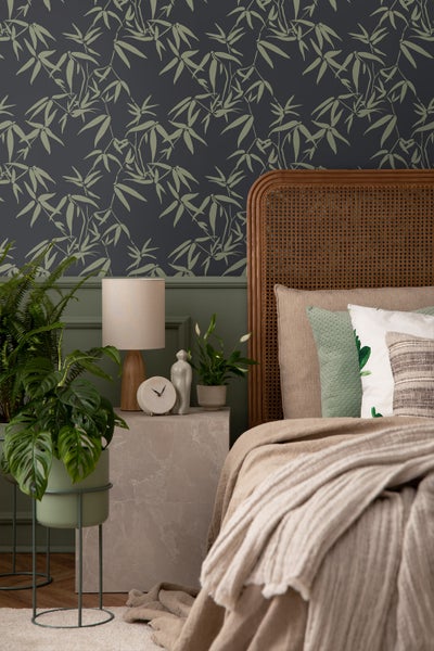 Schlafzimmer mit Bambustapete, Rattankopfteil und Nachttisch mit Dekoration
