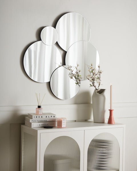 Wanddekoration mit Spiegeln in Kreisform, kombiniert mit Kommode und Dekoration