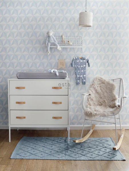 Babyzimmer mit Wickelkommode, Regal, Dekoration und Schaukelstuhl auf einem gemusterten Teppich