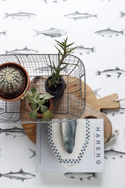 Dekorative Stillleben-Szene mit Pflanzen, Drahtkorb und Kochbuch auf Holzhintergrund