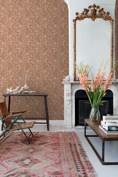 Wohnzimmer mit floral gemusterter Tapete, Sofa und Beistelltisch