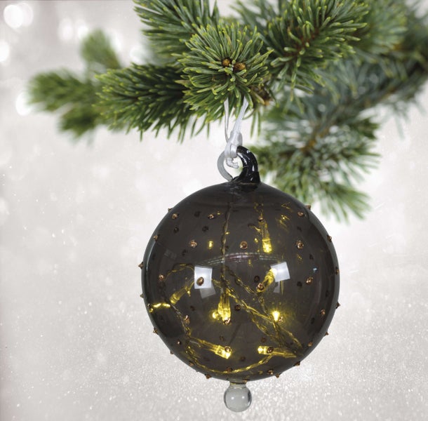 Dekorativer Christbaumschmuck mit LED-Beleuchtung an einem Tannenzweig