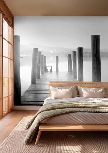 Schlafzimmer mit Fototapete, die einen Steg auf einem See zeigt