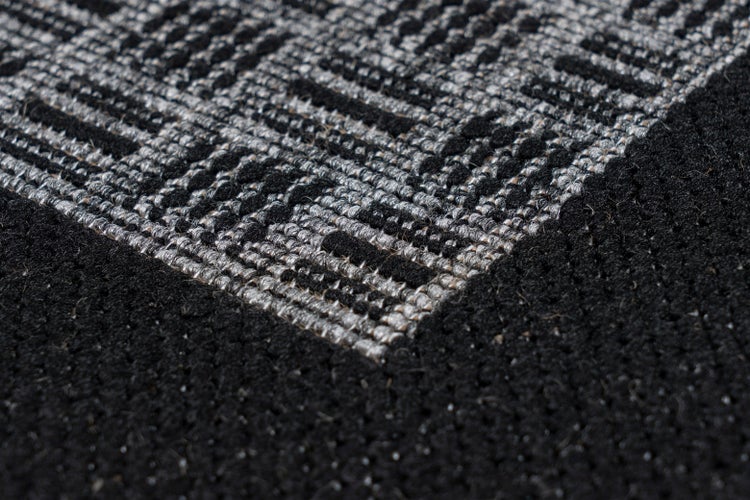 Nahaufnahme eines gewebten Teppichs mit geometrischem Muster.
