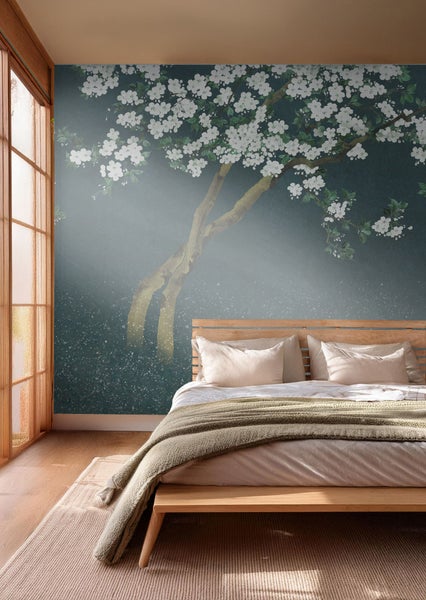 Schlafzimmer mit Bett und Fototapete mit Baum und Blüten