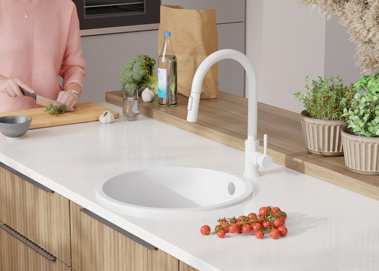 Küchenszene mit Spüle, Armatur und Lebensmitteln auf der Arbeitsfläche.