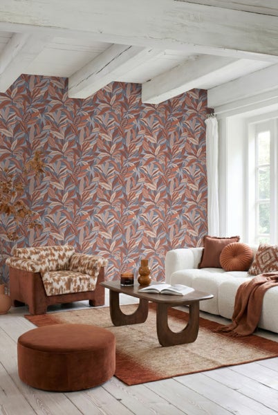 Helles Wohnzimmer mit Vliestapete im Blätterdesign, weißem Sofa, Couchtisch aus Holz und Sessel. Moderner, gemütlicher Einrichtungsstil.