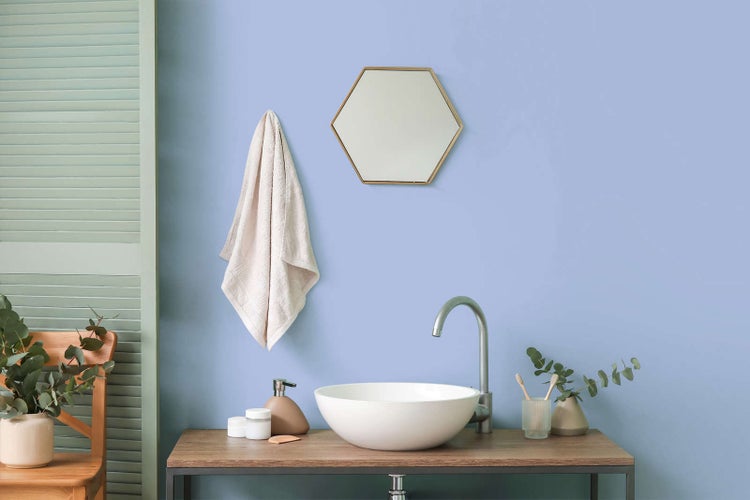 Helles, modernes Badezimmer mit weißem Aufsatzwaschbecken, bogenförmiger Armatur, sechseckigem Spiegel und hölzernem Waschtisch.