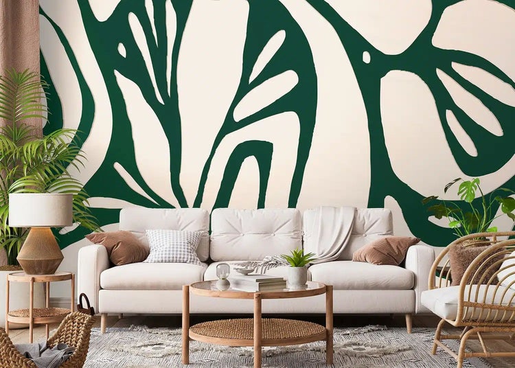 Vlies-Fototapete mit abstraktem botanischen Muster in Dunkelgrün und Weiß in einem modern eingerichteten Wohnzimmer mit Sofa und Holzmöbeln.