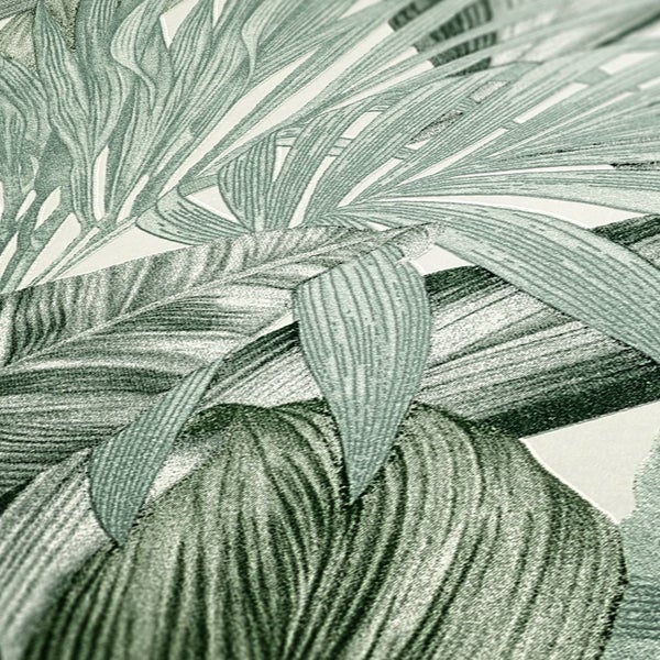 Wohnraum mit tropischer Blättertapete, Pflanze im Topf, Bücher auf einem Tisch und einer Schublade