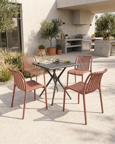 Gartenszene mit einem quadratischen Tisch und vier Stühlen auf einer Terrasse