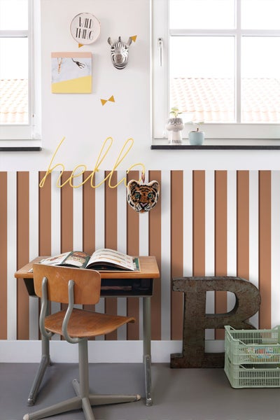 Dekoriertes Kinderzimmer mit Schreibtisch und gestreifter Wand