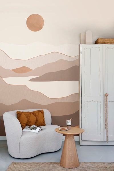 Gemütliche Leseecke mit Sessel, Beistelltisch und dekorativer Berglandschaft-Tapete.