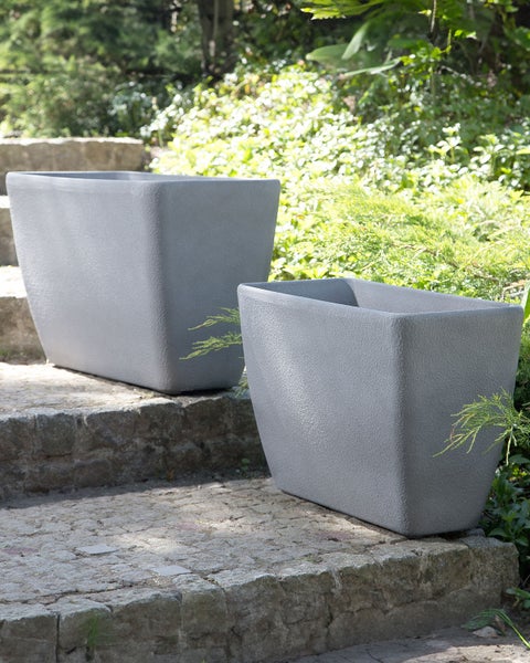 Zwei Pflanzgefäße aus Kunststoff auf einer Steintreppe im Freien.