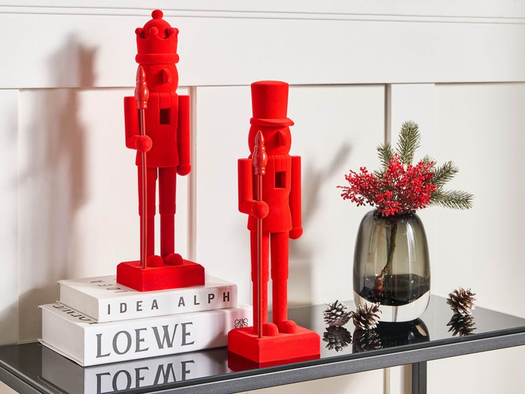 Dekorative Nussknackerfiguren und Vase mit Weihnachtsschmuck auf einem Tisch.
