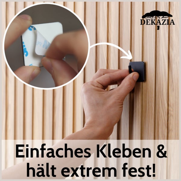 Selbstklebender Wandhaken wird an Holzpaneelwand angebracht. Detailansicht zeigt das Entfernen der Schutzfolie vom Klebestreifen. Dekazia Logo.