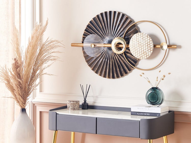 Dekoratives Wandbild aus Metall mit abstraktem Design über einem Konsolentisch mit Vasen und Duftstäbchen.