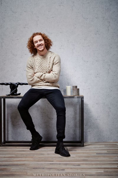 Wohnzimmer mit gemusterter Tapete, Kommode, Dekoration und einem Hund