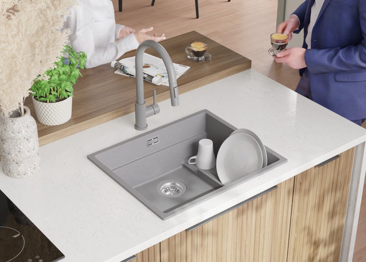 Küchenszene mit Spüle, Armatur und Geschirr auf einer Küchentheke.