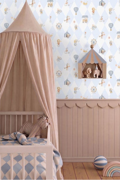 Kinderzimmer mit Zirkus-Tapete im Rautenmuster, einem Gitterbett mit Betthimmel und Wandpaneelen mit Wellenkante.
