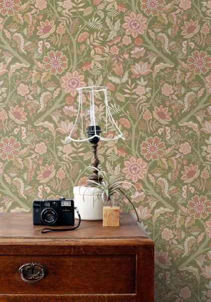 Vintage-Szene mit Blumtapete, Lampe, Pflanze und Kamera auf einem Holzschrank