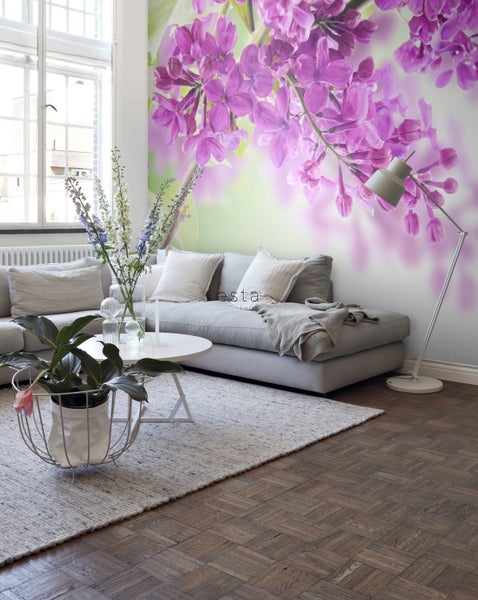 Wohnzimmer mit Sofa, Teppich, Tisch und Fototapete mit Blütenmotiv