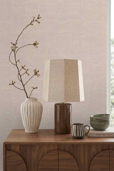 Tapete mit Leinenstruktur in einem minimalistischen Raum mit Holzkommode, Tischleuchte und Dekoration im Wabi-Sabi-Stil.