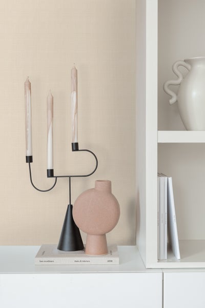 Dekorative Szene mit Kerzenständer, Kerzen und Vasen auf einem Schrank.