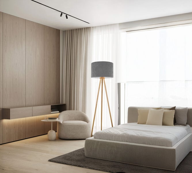 Schlafzimmer mit Bett, Sessel und Stehlampe