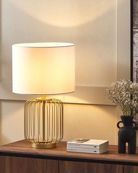 Tischleuchte mit Lampenschirm und Metallgestell auf einem Holztisch