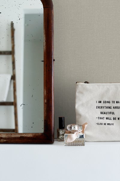 Dekorative Szene mit Spiegel, Nagellack, Parfüm und Kosmetiktasche auf einem Regal