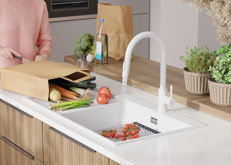 Küchenspüle mit Armatur, Gemüse und Frau beim Kochen