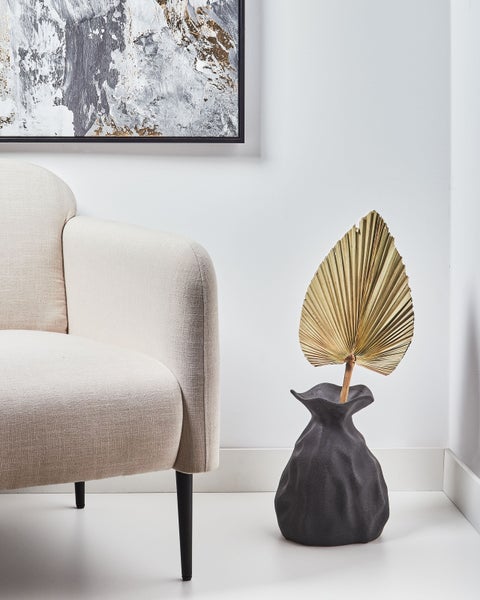 Dekorative Szene mit Sessel, abstraktem Gemälde und Vase mit Trockenblume