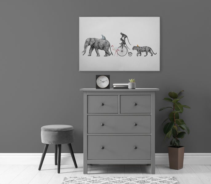 Wohnraumgestaltung mit Kommode, rundem Hocker und Wandbild mit illustrierten Tieren in einer modernen, minimalistischen Einrichtung.