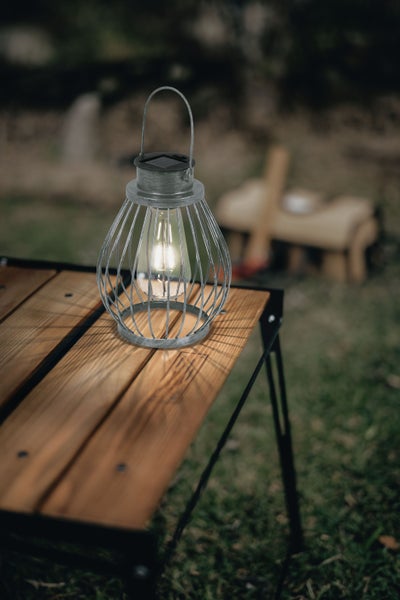 Dekorative Solarleuchte im Metallkäfig-Design auf einem Tisch