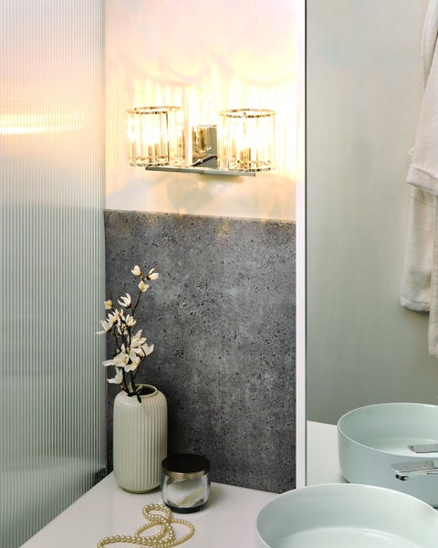 Badezimmer mit Waschbecken, Wandleuchte, Spiegel und Dekorationen