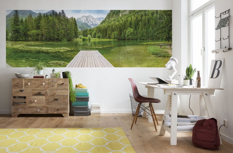 Wohnraum mit Kommode, Schreibtisch und Fototapete mit Bergsee-Motiv