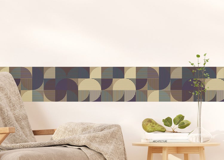 Tapetenbordüre mit geometrischem Kreismuster an einer hellen Wand über einem Sofa in einem modernen Wohnzimmer.