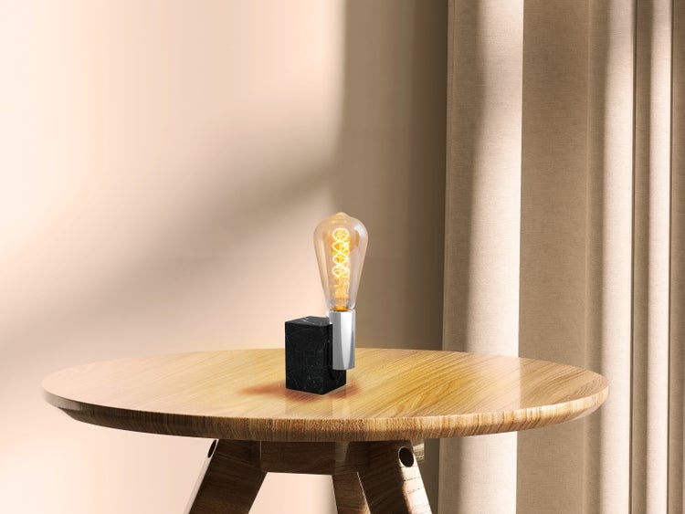 Tischleuchte mit Glühbirne auf rundem Tisch