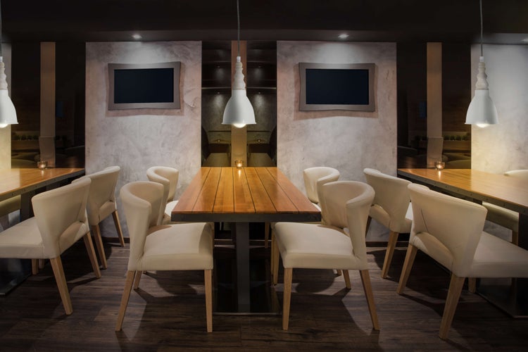 Restaurant mit Holztischen, Stühlen und Pendelleuchten