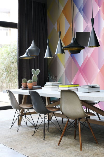 Esszimmer mit Esstisch, Stühlen und Pendelleuchten vor einer gemusterten Tapete