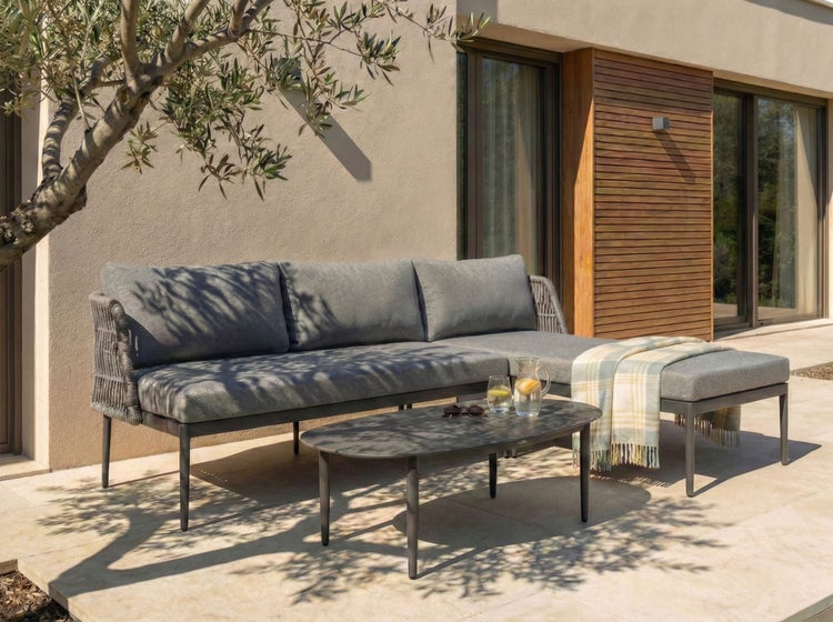 Gartenset mit Sofa, Tisch und Hocker auf einer Terrasse