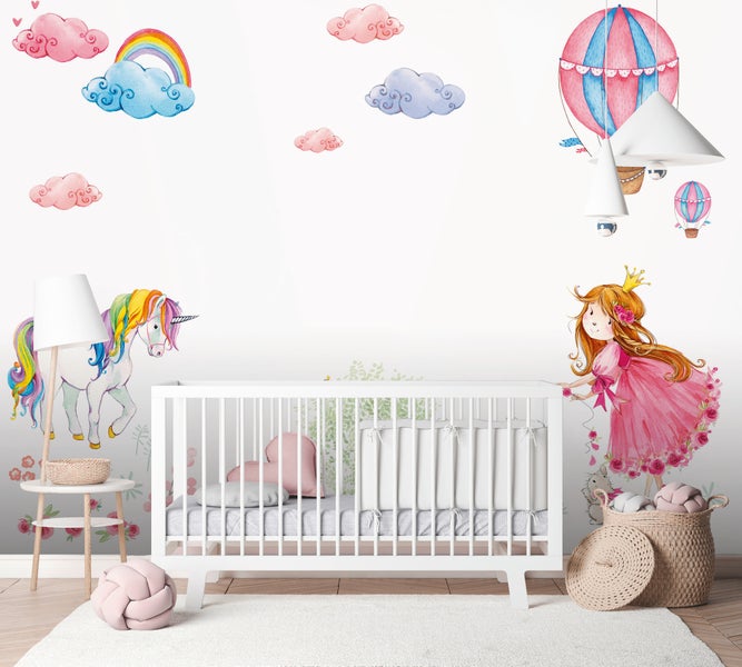 Kinderzimmer mit weißem Babybett und Wandstickern im Aquarell-Stil mit Einhorn, Prinzessin, Regenbogen und Heißluftballon.