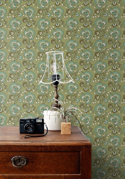 Detailansicht einer gemusterten Tapete mit Lampe und Kommode