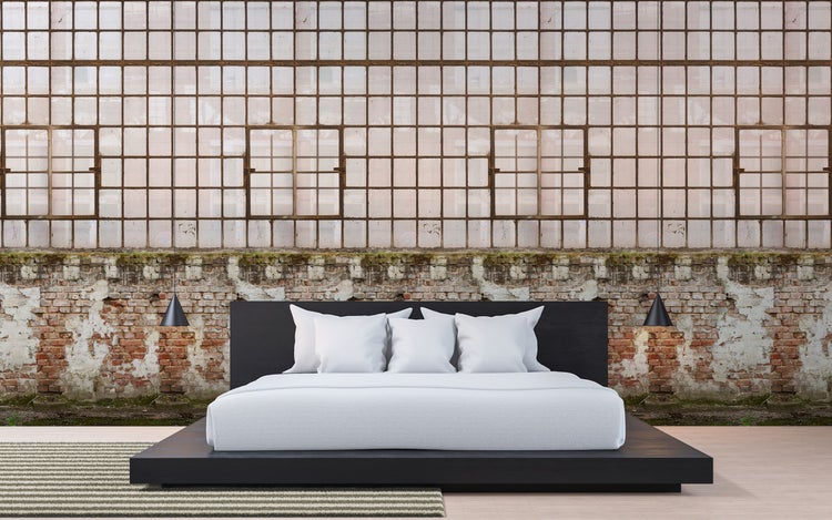 Schlafzimmer mit schwarzem Bett und Ziegelwand