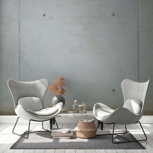 Wohnzimmer mit zwei Sesseln, Teppich und Dekoration auf einem Tisch