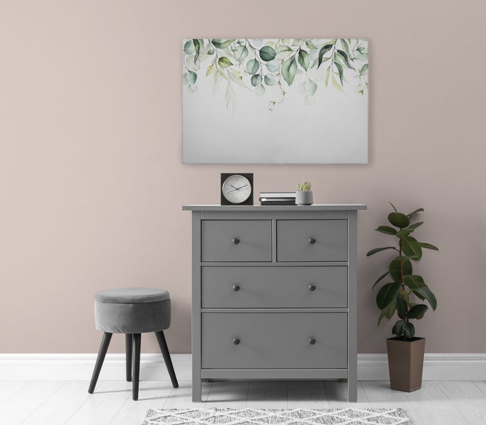 Eine Kommode mit vier Schubladen steht vor einer Wand mit einem botanischen Wandbild, einem Hocker und einer Pflanze.