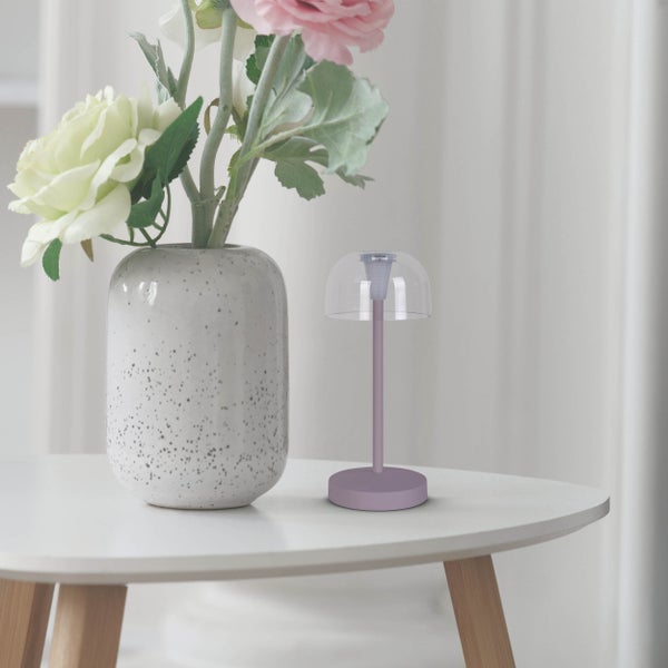 Dekorative Tischleuchte neben einer Vase mit Blumen auf einem Tisch