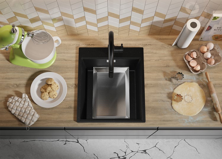 Küchenarbeitsplatte mit Spüle, Küchenmaschine, Plätzchen, Eiern und Teig zum Backen.